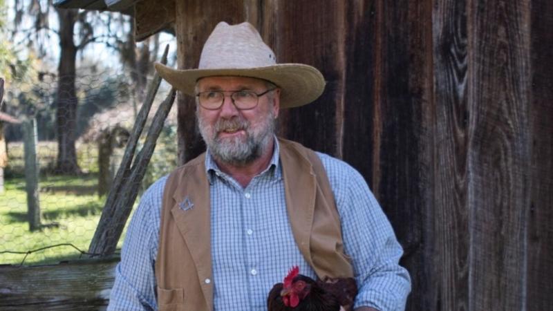 Park ranger Tony Ryan at Dudley Farm holding a chicken